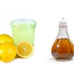 Lemons, a glass of lemon juice, and a bottle of vinegar