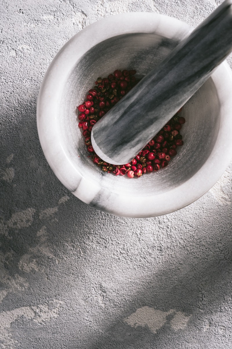 Pestle and mortar grinding red peppercorns