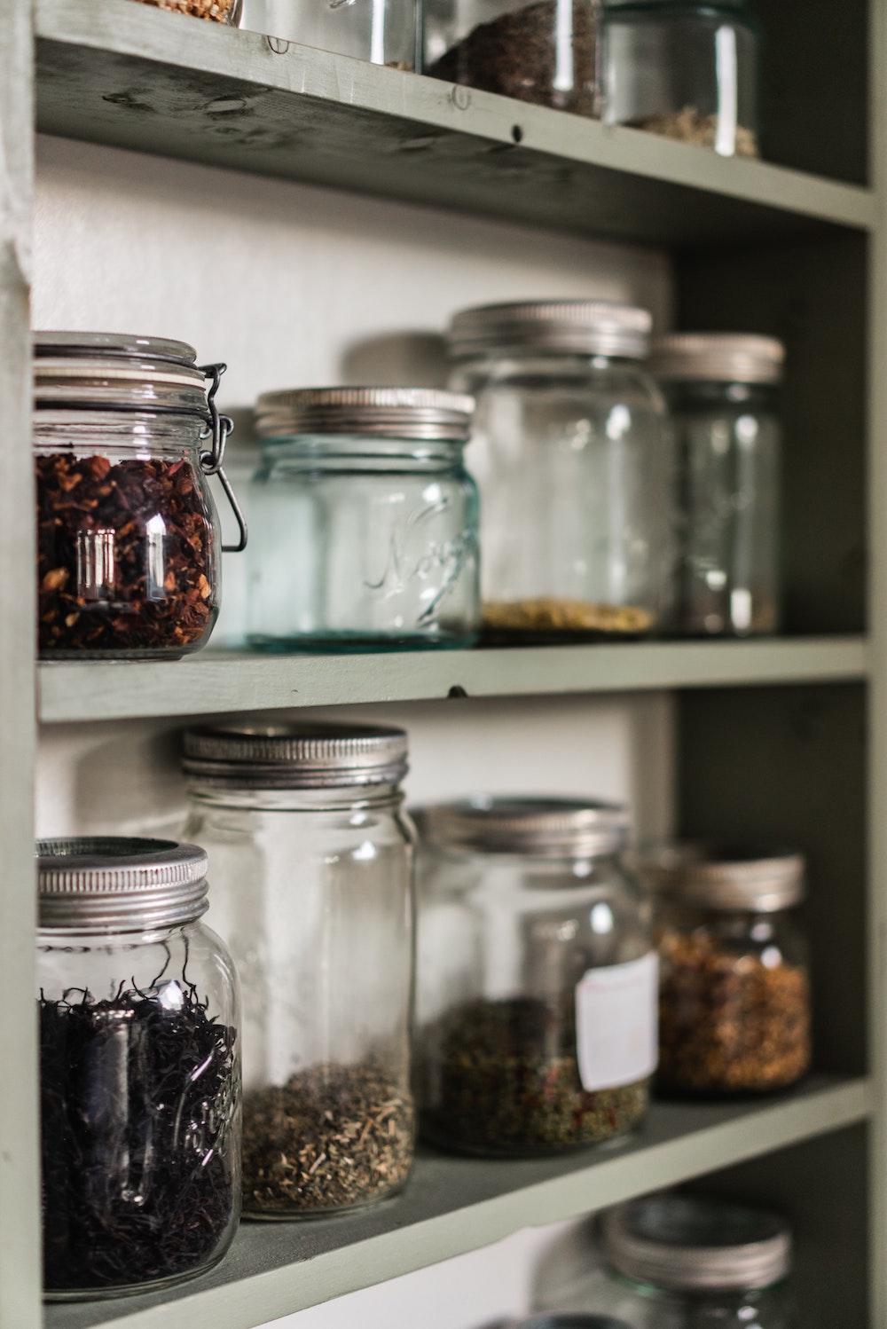 Rows of spice jars on a kitchen shelf