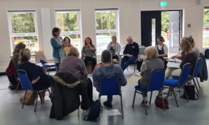 A group of people sitting indoors in a circle